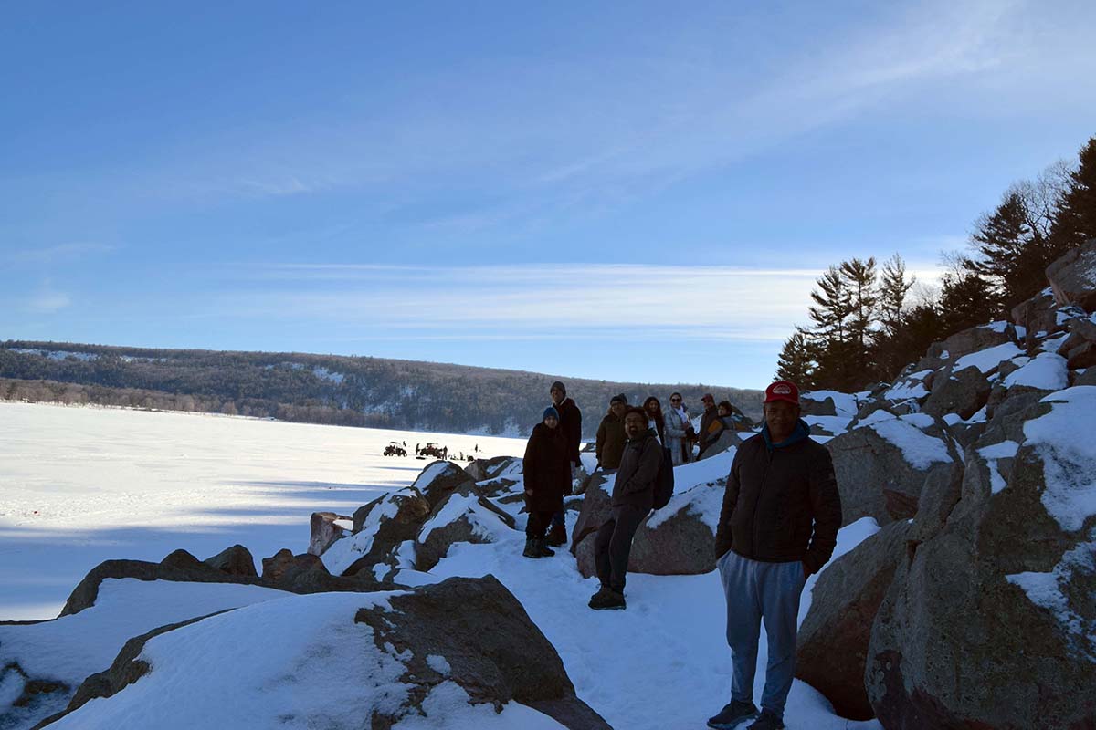 A group standing on a snowy path along the shore of Devil's Lake