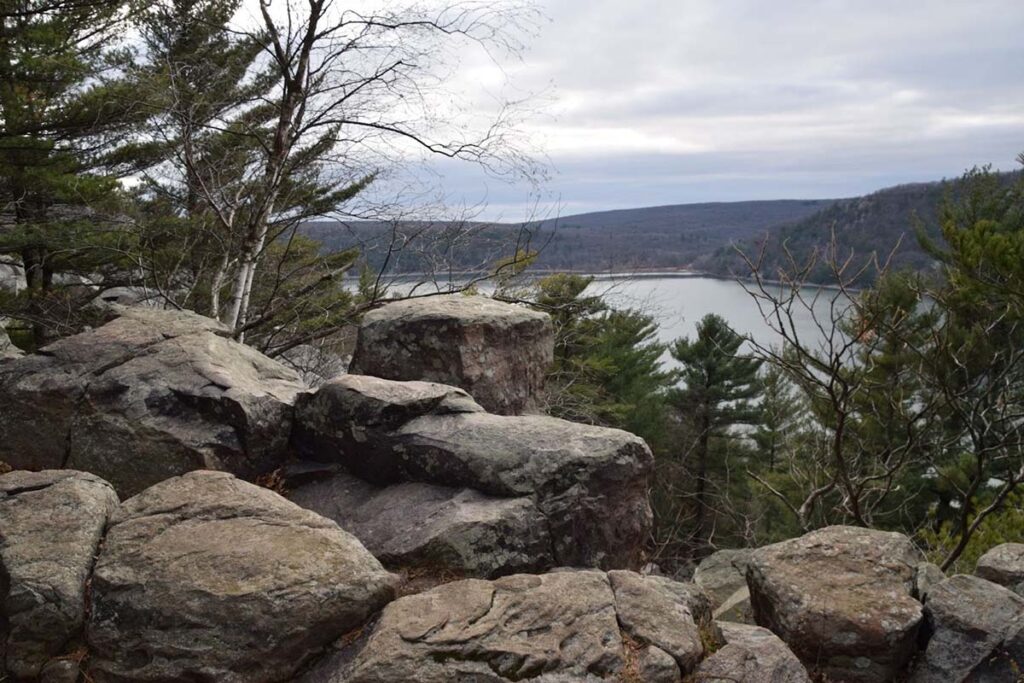 A view of Devil's Lake from atop the bluffs, with evergreen trees and rolling hills in the landscape