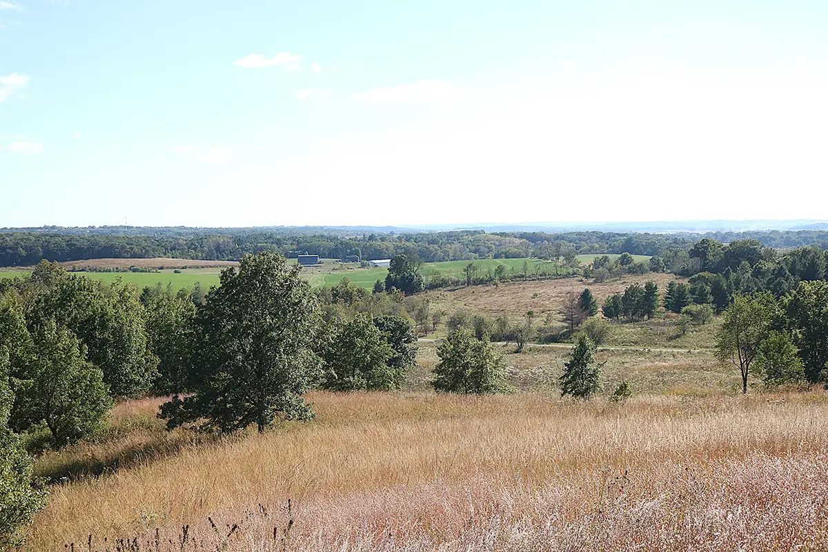 Panoramic view of prairie landscape on a clear day, with rolling hills and farm fields in the background