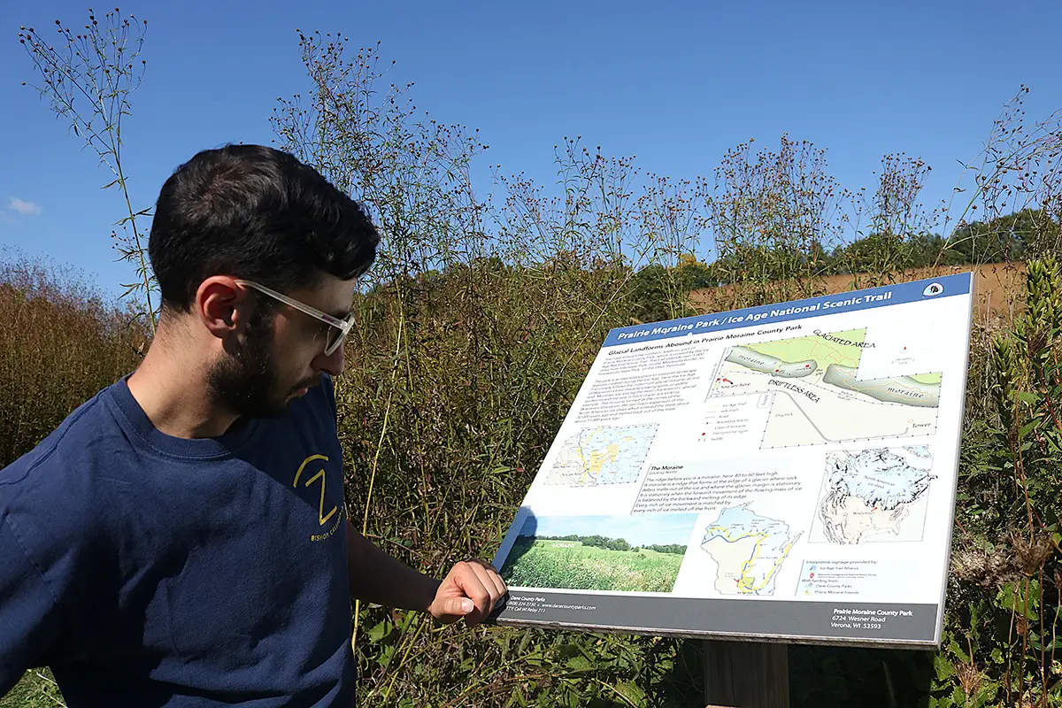 A CHE member reads an informational sign while walking the Ice Age National Scenic Trail