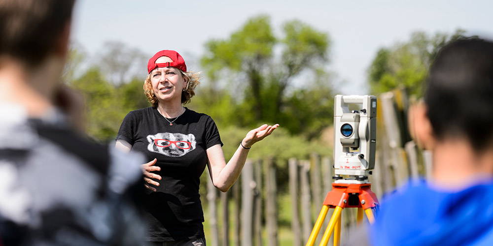 A professor speaking to a group of students on a archaeological dig