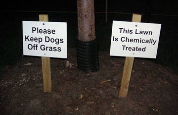 Sign that says "please keep dogs off the grass; this lawn is chemically treated"